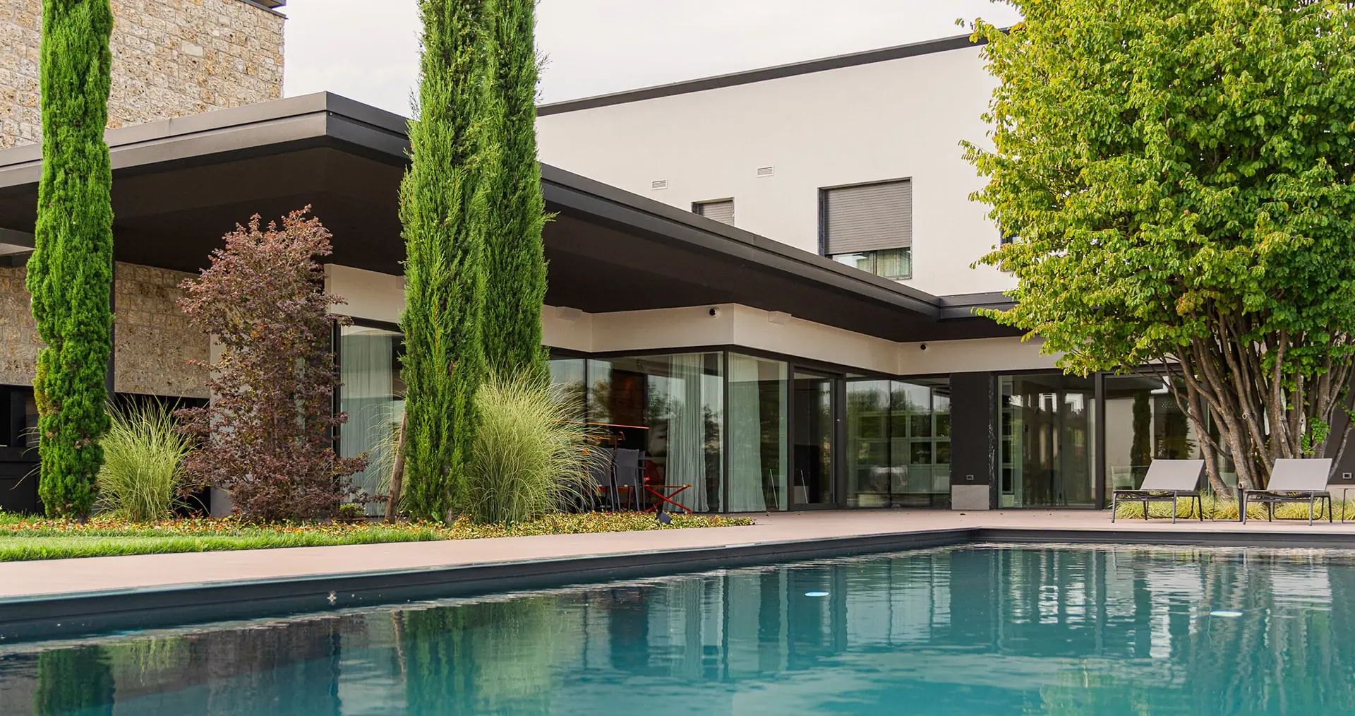 Villa con grandi vetrate scorrevoli affacciate sulla piscina