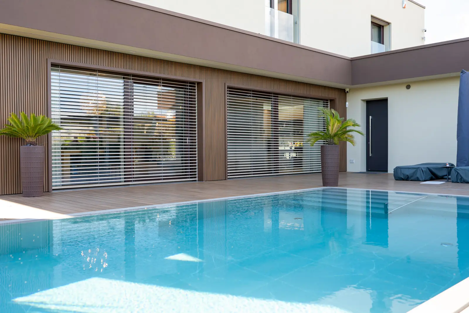 Casa con piscina e vetrate scorrevoli con frangisole